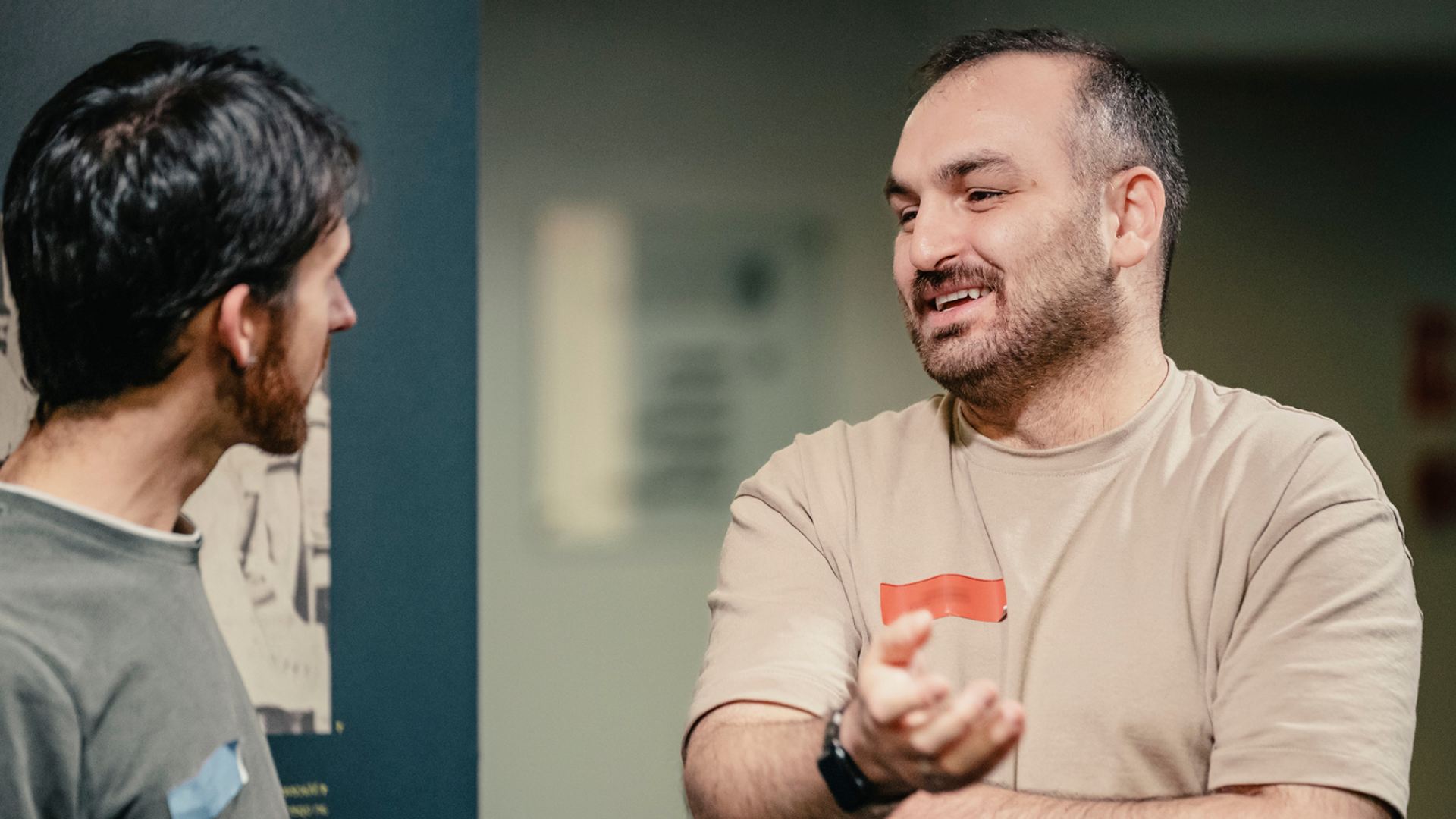 Two participants in conversation in the College's Crush Hall